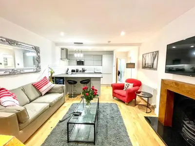 a living room with a couch and a red chair at Prime Edinburgh New Town. Newly reno'd cosy nest in Edinburgh