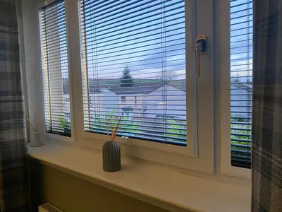 a window with a vase sitting on a window sill at Holiday Apartment, Balloch, Loch Lomond in Balloch