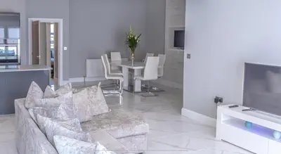 a living room with a couch and a table at 4 Bed-Sleeps 8- Free Parking-Pets-Hot Tub in Kelty