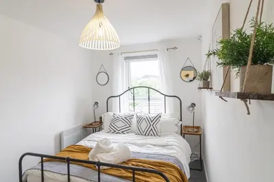 a bedroom with a bed with white sheets and pillows at Luxury Glasgow Flat in the heart of the Westend in Glasgow