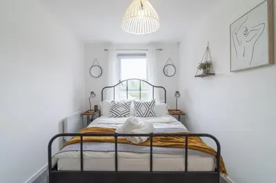 a bedroom with a bed in a white room at Luxury Glasgow Flat in the heart of the Westend in Glasgow