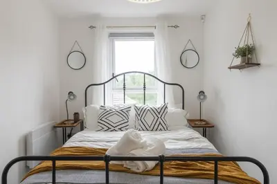 a bedroom with a bed with white sheets and a window at Luxury Glasgow Flat in the heart of the Westend in Glasgow