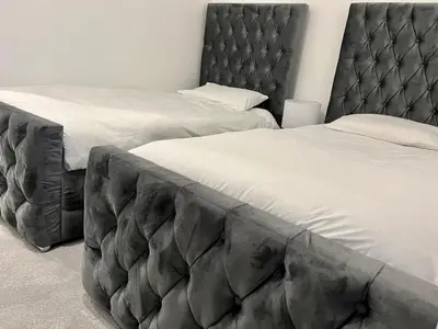 two twin beds in a bedroom with a large headboard at Glasgow City Central Executive Triplex House, 3 Bedroom 3 Bathrooms 1 living room Kitchen - Huge Terrace for Master Bedroom - Private E Parking LEZ Congestion Zone Free - Garden - 5 mins drive to City Centre Central Station in Glasgow