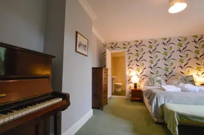 a bedroom with a bed and a piano in it at Cologin in Oban