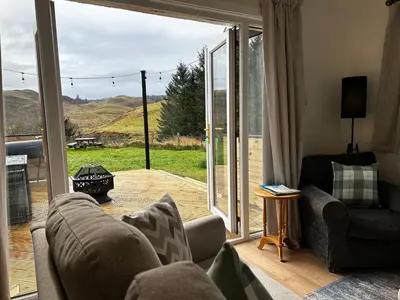 a living room with a couch and a large sliding glass door at Cologin in Oban