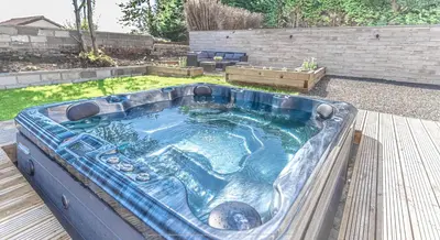 a hot tub in the middle of a yard at 1 Bed Cottage-Sleeps 2-Parking-Pets-Hot Tub in Kelty