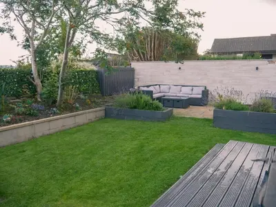 a small garden with a couch in the grass at 1 Bed Cottage-Sleeps 2-Parking-Pets-Hot Tub in Kelty