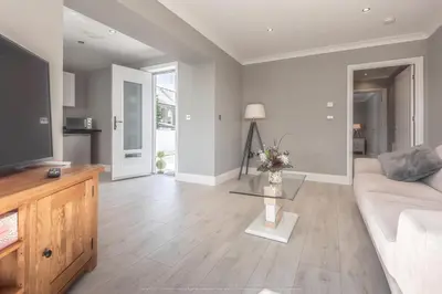 a living room with a couch and a tv at 1 Bed Cottage-Sleeps 2-Parking-Pets-Hot Tub in Kelty