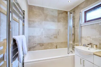 a bathroom with a bath tub and a sink at Portnellan in Crianlarich