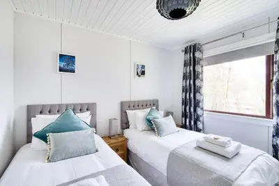 two beds in a room with a window at Portnellan in Crianlarich