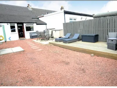 a backyard with a patio furniture and a fence at Cheerful One bedroom cottage with parking space. in Glasgow