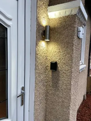 a stone wall with a light on the side of a building at Cheerful One bedroom cottage with parking space. in Glasgow