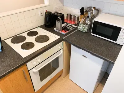 a kitchen with a stove and a microwave at Glasgow City Centre Studio Apartment in Glasgow