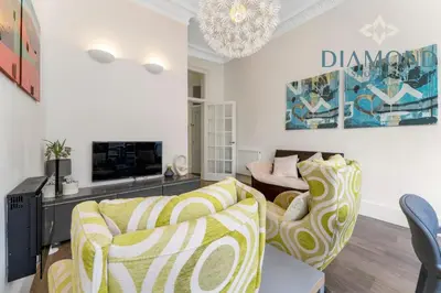 a living room with two couches and a tv at Spacious 1 Bed Ground Floor Apartment with Garden in Edinburgh