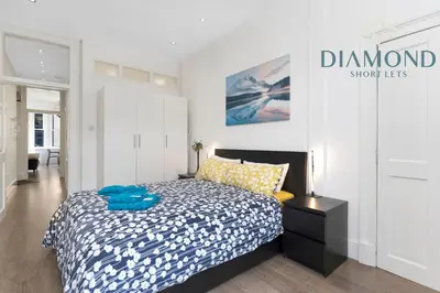 a bedroom with a bed and a sign on the wall at Spacious 1 Bed Ground Floor Apartment with Garden in Edinburgh