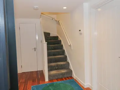 a staircase in a home with a green rug at Dunaivon Cottage in Helensburgh