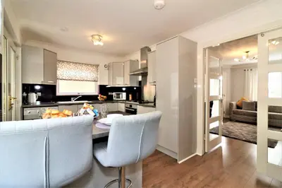 a kitchen with a table and chairs in a room at Signature - Culzean House in Newarthill
