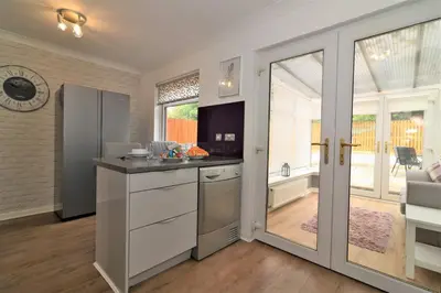 a kitchen with an open door to a patio at Signature - Culzean House in Newarthill
