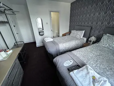 a hotel room with two beds and a sink at DunMoore Guesthouse in Oban