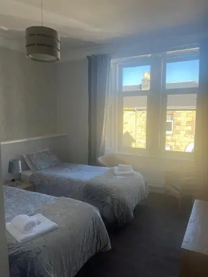 a hotel room with two beds and a window at DunMoore Guesthouse in Oban