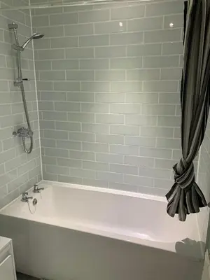 a white bath tub in a bathroom with a shower at The Cochno Flat, Clydebank in Dalmuir