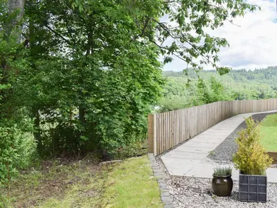 a walkway in a yard next to a fence at Craigmore View-Uk34220 in Aberfoyle