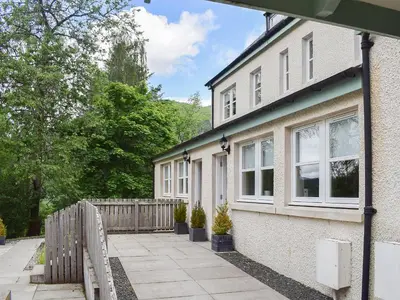 a white house with a fence and trees at Craigmore View-Uk34220 in Aberfoyle