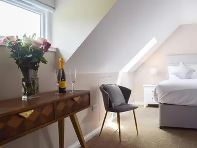 a bedroom with a bed and a table with a vase of flowers at Craigmore View-Uk34220 in Aberfoyle