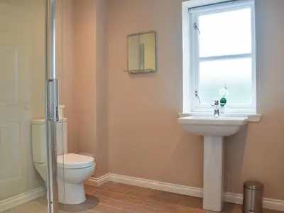 a bathroom with a toilet and a sink and a window at Craigmore View-Uk34220 in Aberfoyle