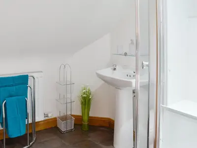 a white bathroom with a sink and a shower at Stronvaar in Stranraer