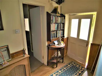 a room with a door and a table and a book shelf at Tigh Na Maraiche in Isle of Jura
