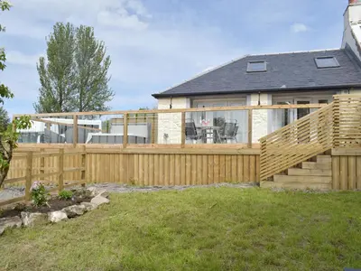 a house with a wooden fence and a deck at Uk7385 - Chaff House in Newmilns