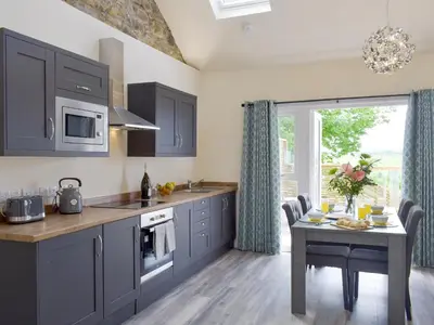a kitchen with blue cabinets and a table with a table at Uk7385 - Chaff House in Newmilns