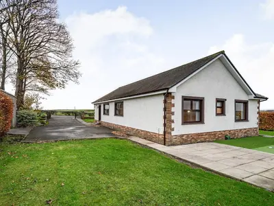 a white house with a driveway and grass at Rowan Muir in Springside