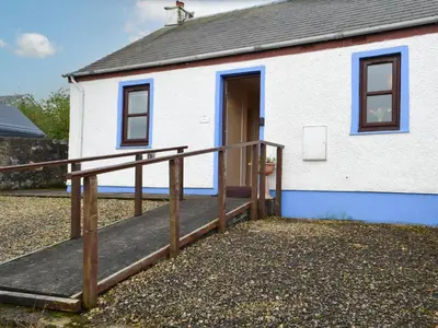 a small white building with a ramp leading to a door at Ashley Cottage in Bowmore