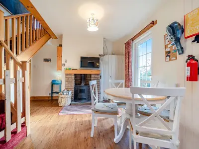 a dining room with a table and chairs and a fireplace at The Creagan in Corrie