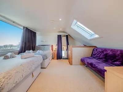a bedroom with two beds and a couch and a window at The Creagan in Corrie