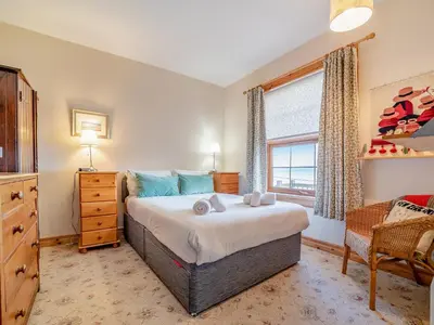 a bedroom with a large bed and a window at The Creagan in Corrie