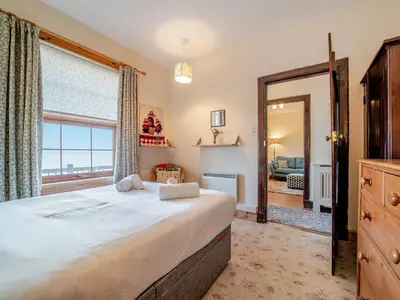 a bedroom with a large bed and a large window at The Creagan in Corrie