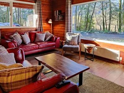 a living room with red couches and a table at Willow Lodge in Rashfield