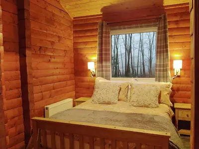 a bedroom with a bed in a log cabin at Willow Lodge in Rashfield