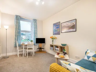 a living room with a couch and a table at Boyd Apartment in Largs