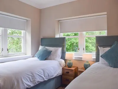 two beds in a bedroom with two windows at Forth View-Uk34217 in Aberfoyle