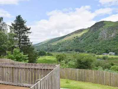 a wooden fence with mountains in the background at Forth View-Uk34217 in Aberfoyle