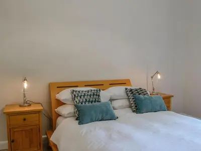 a bedroom with a bed with two pillows on it at Lime Tree Cottage in Drumpark