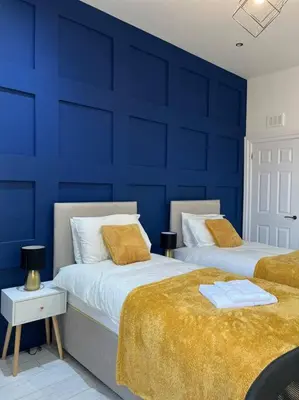 two beds in a room with blue walls at Cheerful 2 Bedroom Homely Apartment, Sleeps 4 Guest Comfy, 3x Double Bed, Parking, Free WiFi, Suitable For Business, Leisure Guest,Glasgow, Glasgow West End, Near City Centre, Perfect For Common Wealth Games 2026 in Glasgow