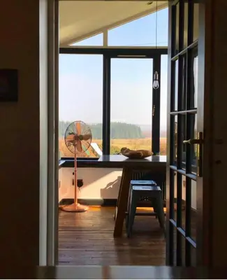 a room with a desk and a window with a fan at Trossachs Barn & Cabin - boutique B&B in Port of Menteith