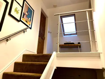 a staircase with a mirror on the wall in a room at Trossachs Barn & Cabin - boutique B&B in Port of Menteith
