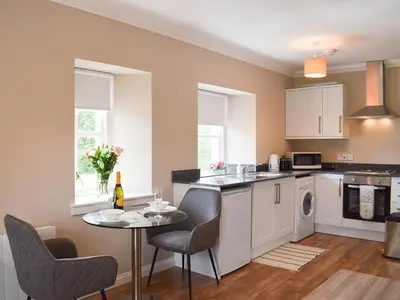 a kitchen with a table and chairs and a kitchen with a sink at Fascadail-Uk34219 in Aberfoyle