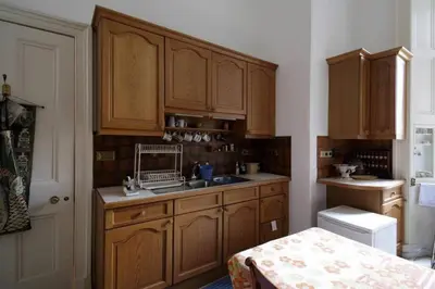 a kitchen with wooden cabinets and a sink at Quirky, West End, Edinburgh House in Edinburgh
